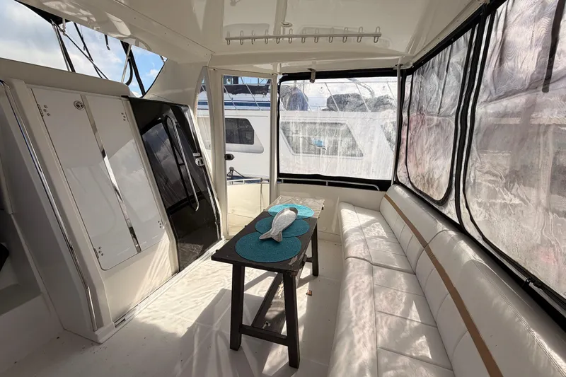 Slide: The Image of 2005 Carver 41 Cockpit Motor Yacht interior with seating and table, featuring large windows. - 11