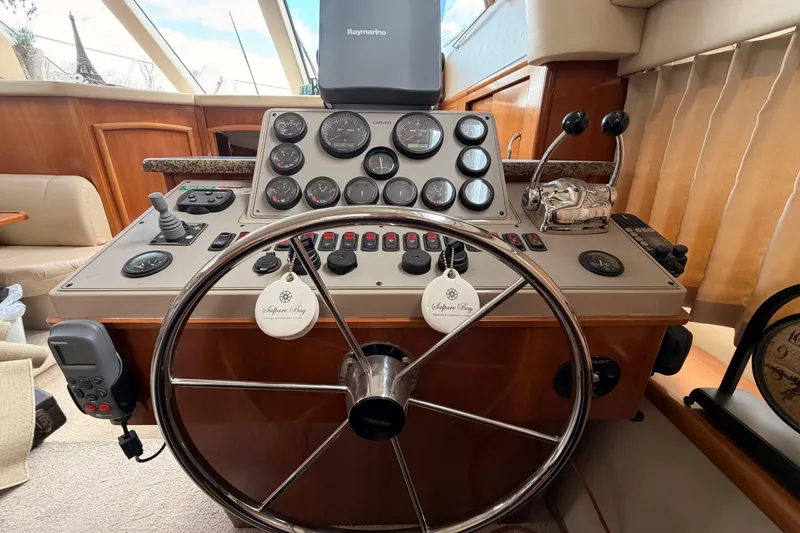 Slide: The Image of Control panel of a 2005 Carver 41 Cockpit Motor Yacht with steering wheel and gauges. - 15