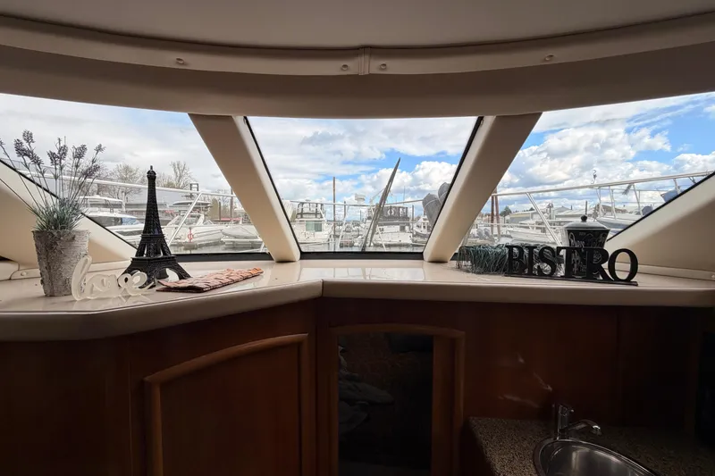 Slide: The Image of Interior view of 2005 Carver 41 Cockpit Motor Yacht with decorative items and marina backdrop. - 16