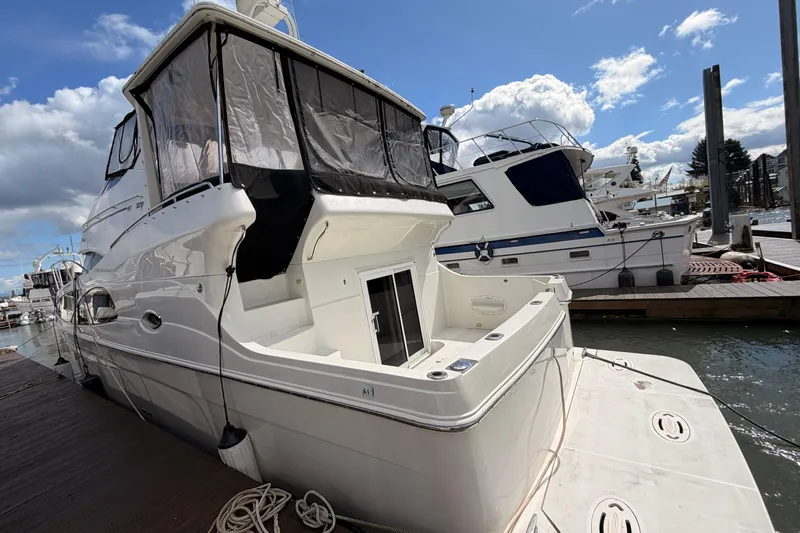 Slide: The Image of 2005 Carver 41 Cockpit Motor Yacht docked at marina under blue sky. - 2