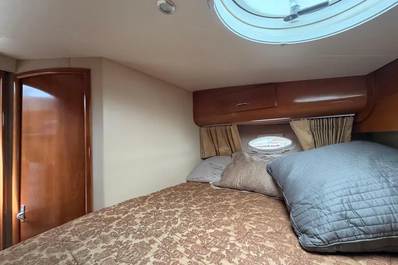 Slide: The Image of Cozy bedroom in 2005 Carver 41 Cockpit Motor Yacht with porthole and wooden accents. - 20