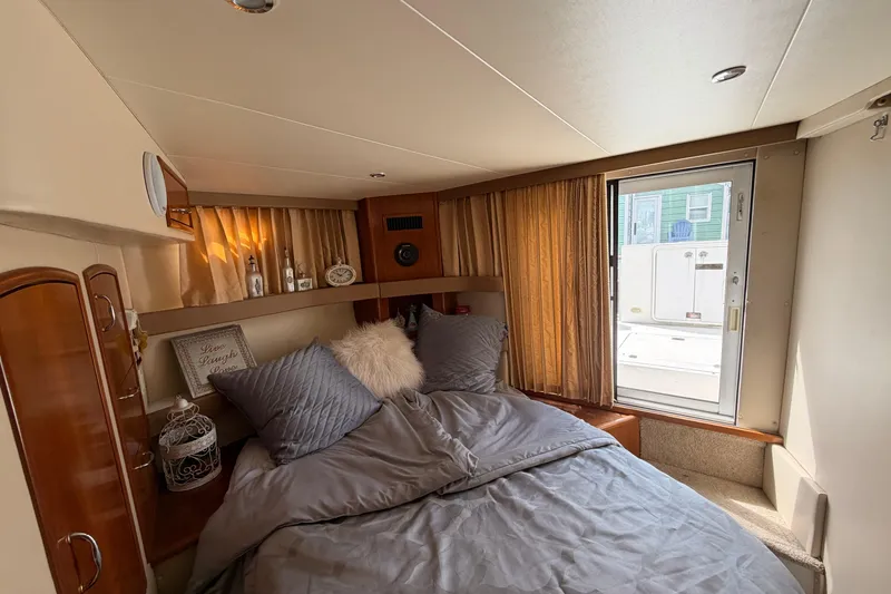 Slide: The Image of Cozy bedroom in 2005 Carver 41 Cockpit Motor Yacht with plush bedding and natural light. - 28