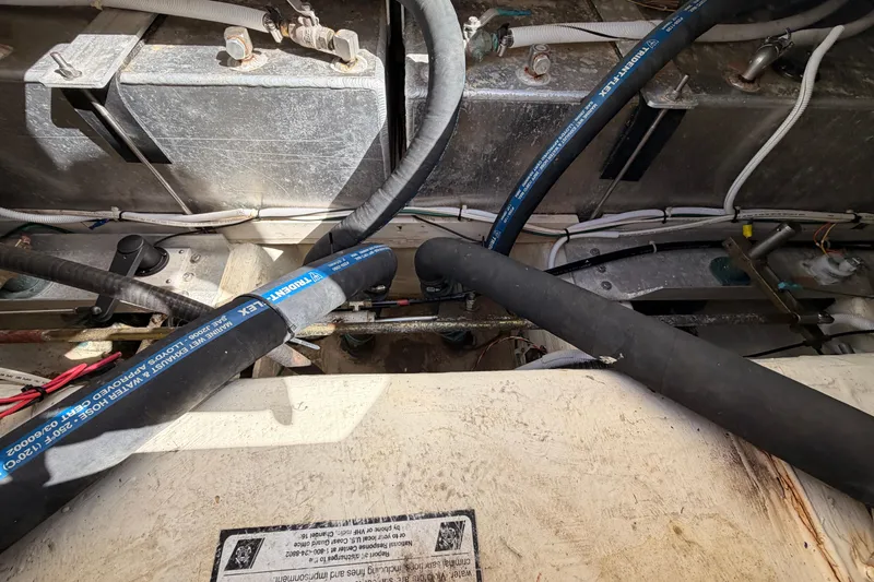 Slide: The Image of Engine compartment of a 2005 Carver 41 Cockpit Motor Yacht, showing hoses and wiring. - 36