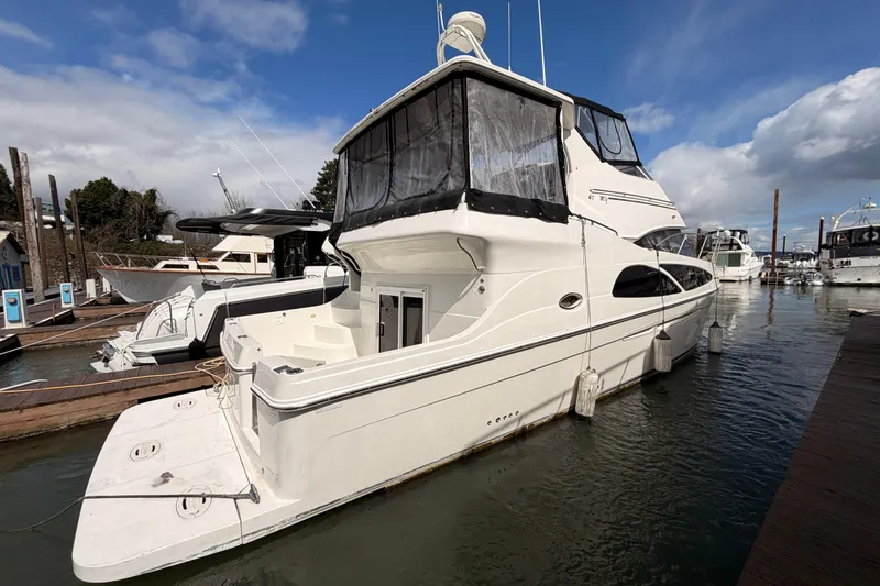 Slide: The Image of 2005 Carver 41 Cockpit Motor Yacht docked at marina under blue sky. - 5