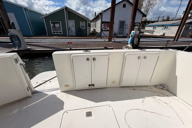 Slide: The Image of 2005 Carver 41 Cockpit Motor Yacht docked, showcasing storage compartments and marina view. - 9