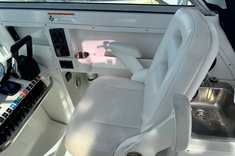 Slide: The Image of Interior of 2011 Glacier Bay 2670 Cuddy boat, featuring helm seat and control panel. - 16