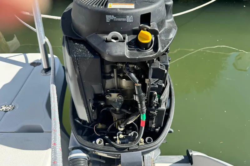 Slide: The Image of Open outboard motor of a 2011 Glacier Bay 2670 Cuddy boat, docked by water. - 22