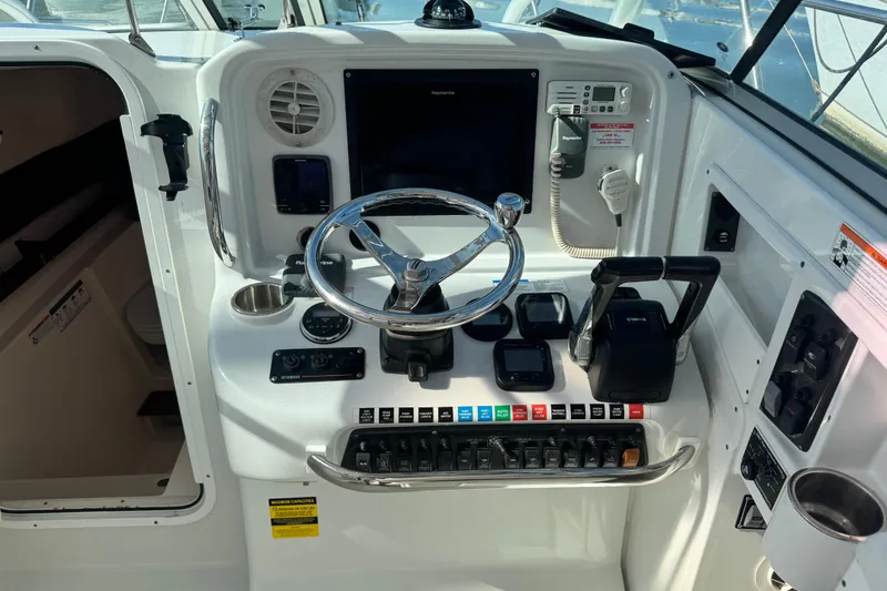 Slide: The Image of 2011 Glacier Bay 2670 Cuddy helm with steering wheel, controls, and navigation equipment. - 42