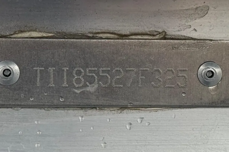 Slide: The Image of Serial number plate on 2025 Manitou EXPLORE 24 with visible screws and water droplets. - 27