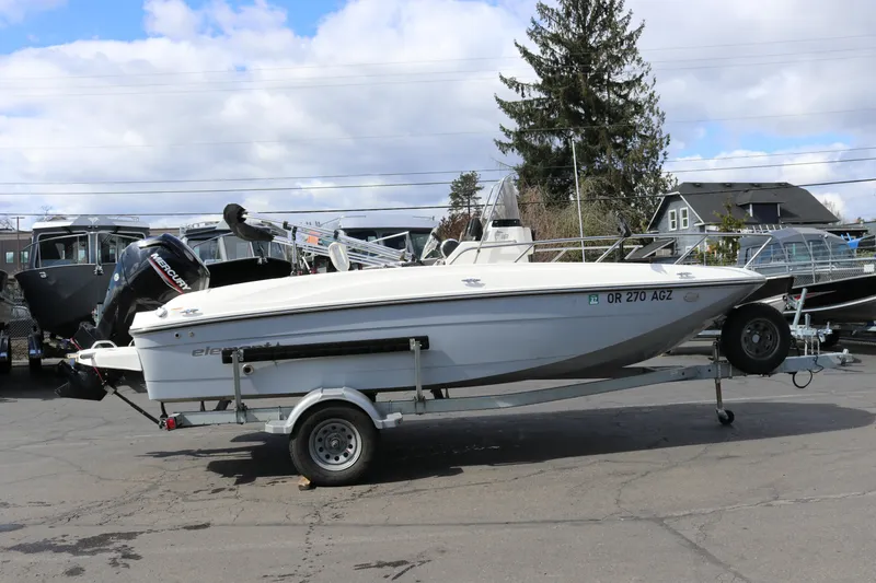 The Image of 2020 Bayliner Element boat on trailer, parked outdoors under cloudy sky. - 1