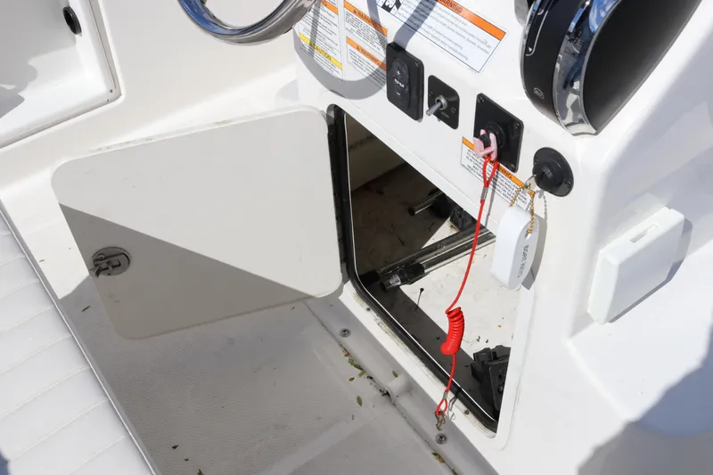 Slide: The Image of 2020 Bayliner Element boat dashboard with open storage compartment and safety features. - 18