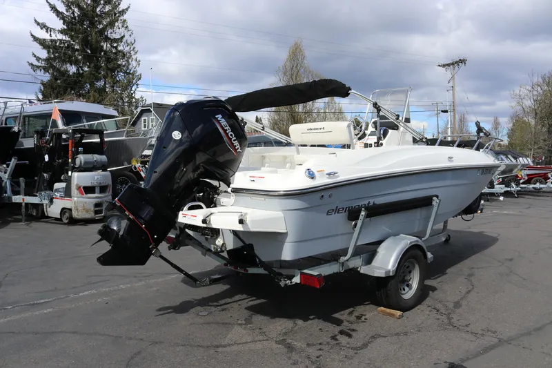 Slide: The Image of 2020 Bayliner Element boat on trailer with Mercury outboard motor in a parking lot. - 2