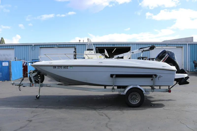 Slide: The Image of 2020 Bayliner Element boat on trailer, parked outdoors near industrial buildings. - 4