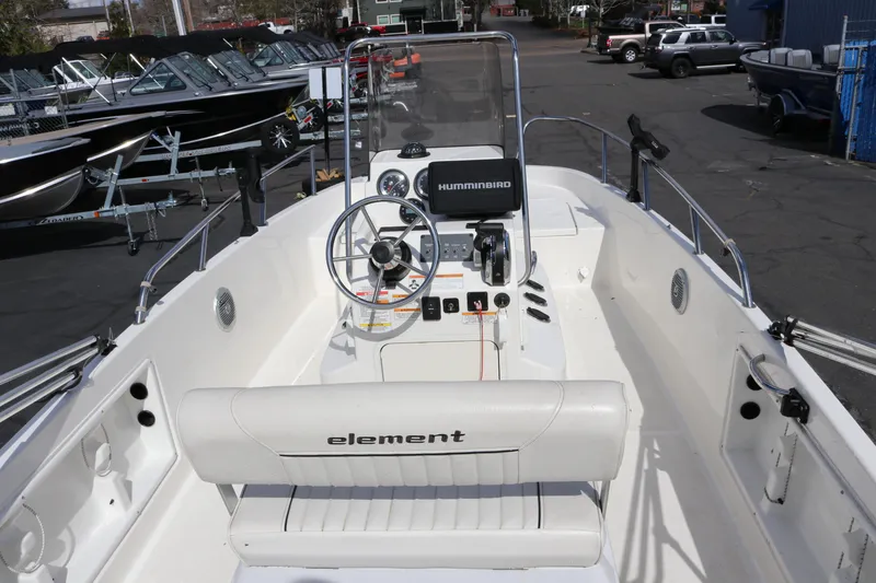 Slide: The Image of 2020 Bayliner Element boat interior with steering wheel and control panel, docked outdoors. - 7