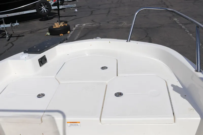 Slide: The Image of 2020 Bayliner Element boat deck with storage compartments and railing in a parking lot. - 9