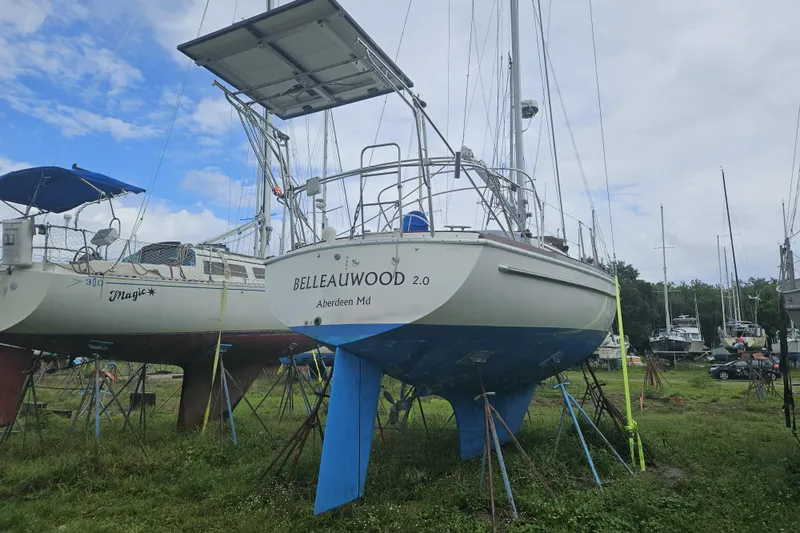 Slide: The Image of 1977 Gulfstar 37 sailboat on land, with blue hull and solar panels, in a boatyard. - 19