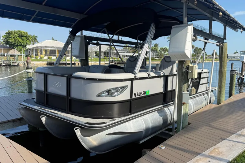 The Image of 2021 Bentley Pontoons 220/223 Elite Admiral docked at a marina under a canopy. - 1