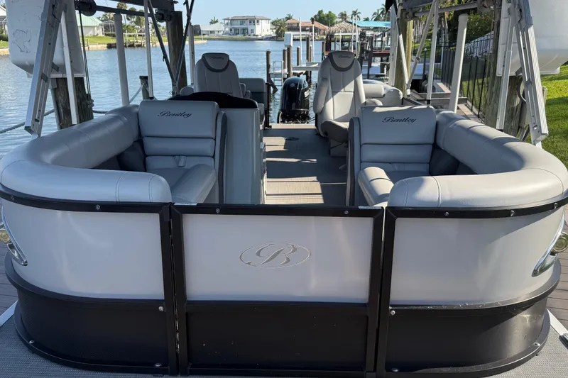 Slide: The Image of 2021 Bentley Pontoons 220/223 Elite Admiral with luxurious seating on a serene waterfront. - 3