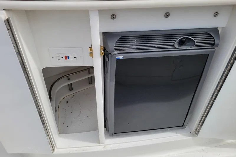 Slide: The Image of 2002 Cobalt 293 boat interior with a small refrigerator and electrical outlet. - 10