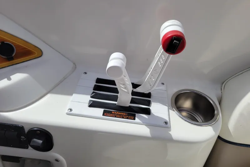 Slide: The Image of Throttle controls on a 2002 Cobalt 293 boat dashboard with cup holder. - 18