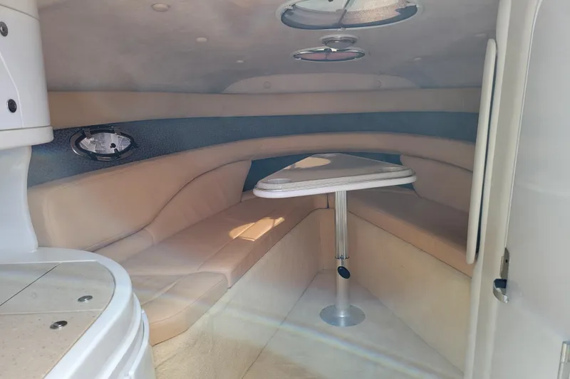 Slide: The Image of Interior of a 2002 Cobalt 293 boat with beige seating and a small table. - 21