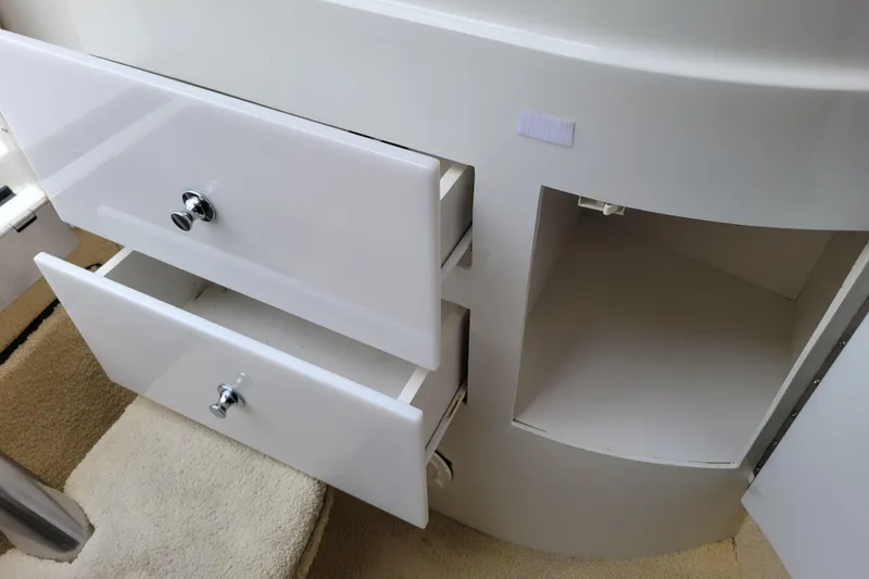 Slide: The Image of White drawers and open cabinet in a 2002 Cobalt 293 boat interior. - 25