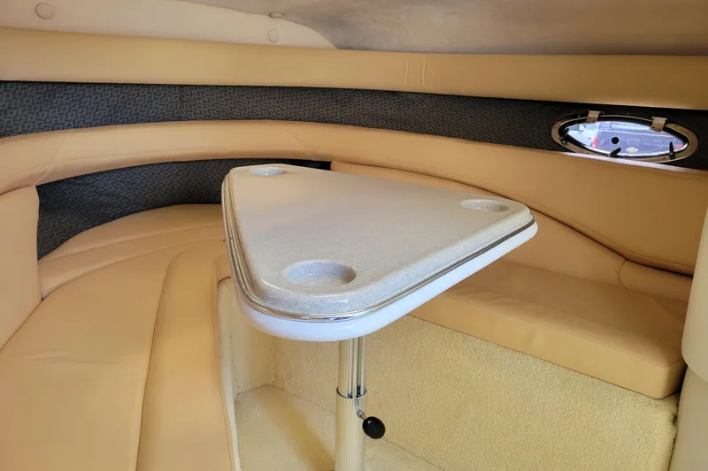 Slide: The Image of Interior of a 2002 Cobalt 293 boat with beige seating and a triangular table. - 27