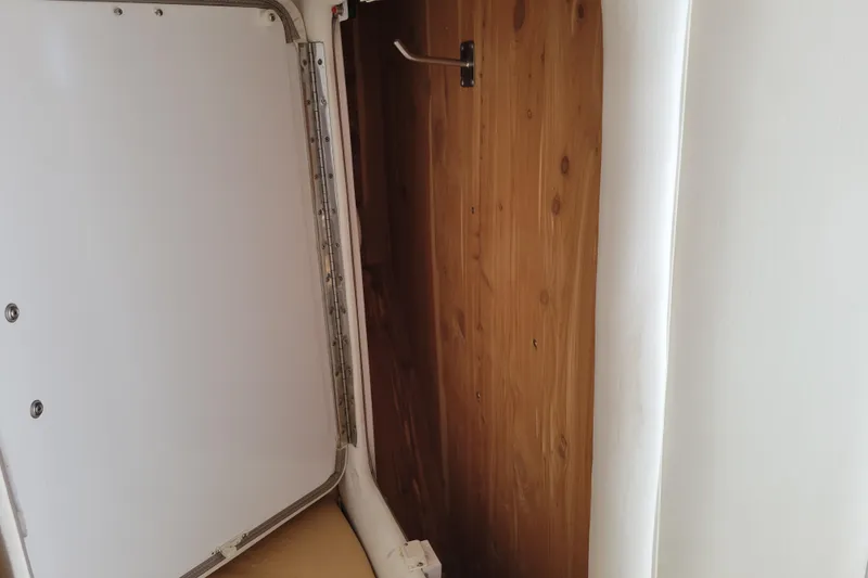 Slide: The Image of Open storage compartment in 2002 Cobalt 293 boat, featuring wooden interior paneling. - 28