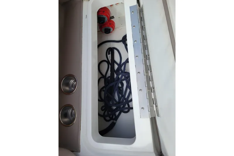 Slide: The Image of Storage compartment in a 2002 Cobalt 293 boat, featuring ropes and red switches. - 38