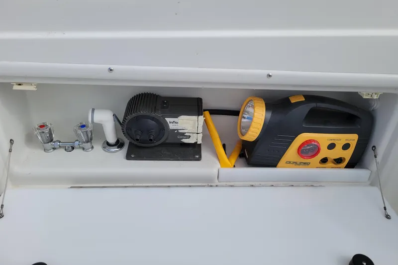 Slide: The Image of Storage compartment in a 2002 Cobalt 293 boat with air compressor and faucet. - 39