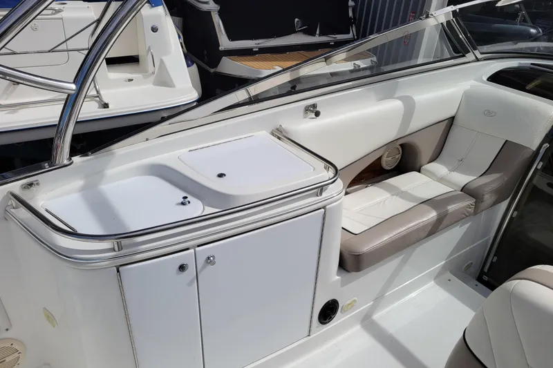 Slide: The Image of Interior of a 2002 Cobalt 293 boat featuring white seating and storage compartments. - 8