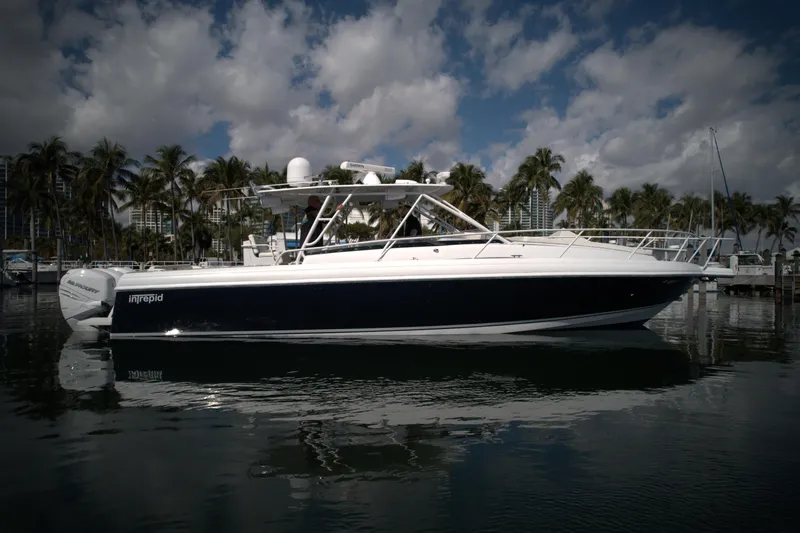 Slide: The Image of 2002 Intrepid 377 Walkaround Cuddy boat docked in a marina with palm trees. - 10