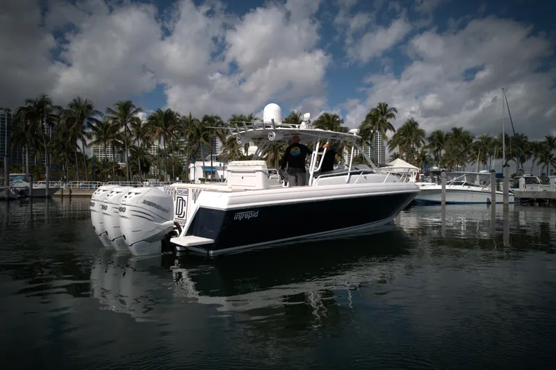 Slide: The Image of 2002 Intrepid 377 Walkaround Cuddy boat docked in a marina. - 13