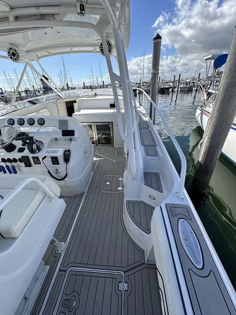 Slide: The Image of 2002 Intrepid 377 Walkaround Cuddy boat docked at marina, showcasing helm and deck. - 32