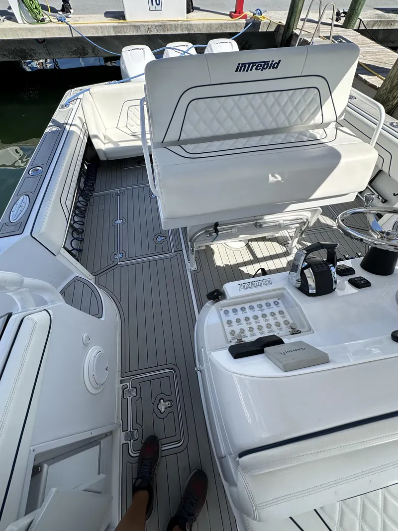 Slide: The Image of 2002 Intrepid 377 Walkaround Cuddy boat interior with seating and control panel. - 45