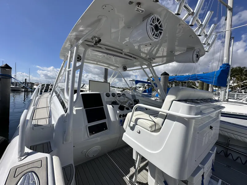 Slide: The Image of 2002 Intrepid 377 Walkaround Cuddy boat interior with helm station and seating. - 49