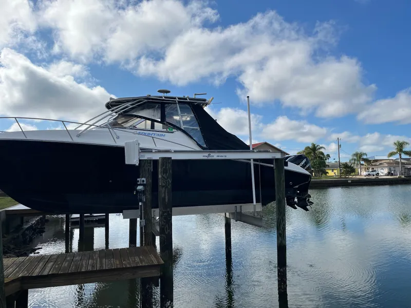 Slide: The Image of 2006 Fountain 33 Sport Fisherman on boat lift by water. - 1