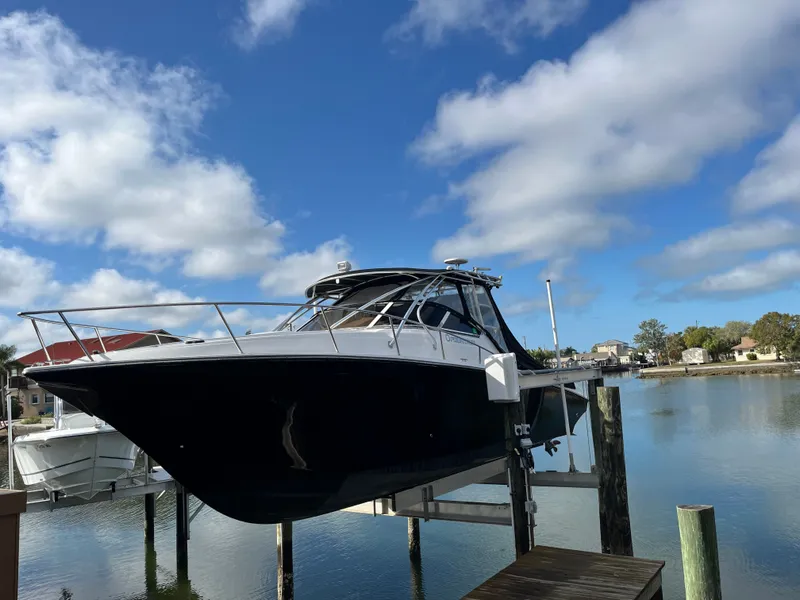 Slide: The Image of 2006 Fountain 33 Sport Fisherman on boat lift by water. - 2