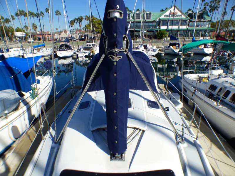 Slide: The Image of 1998 Hunter 34 sailboat docked in marina, surrounded by other boats. - 7