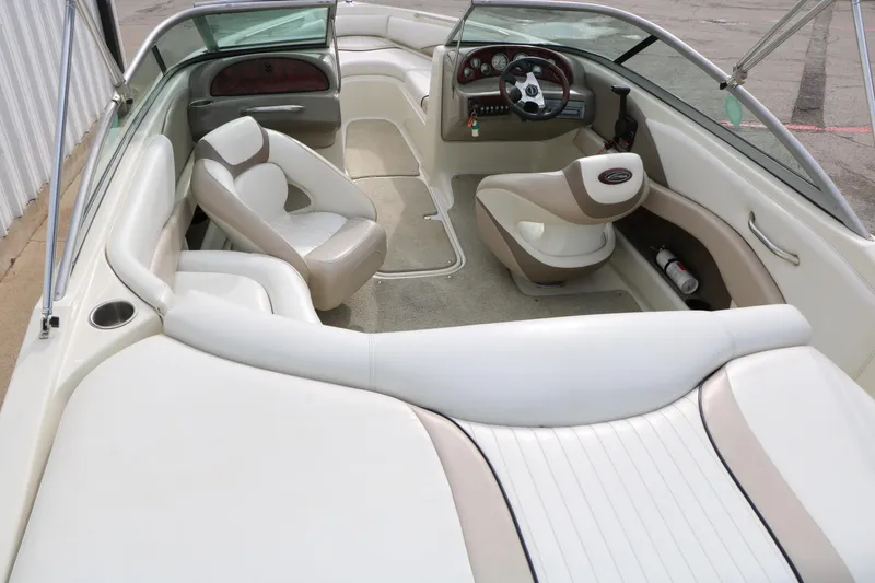 Slide: The Image of Interior of a 2006 Caravelle 207 Bow Rider boat with white and beige seating. - 12