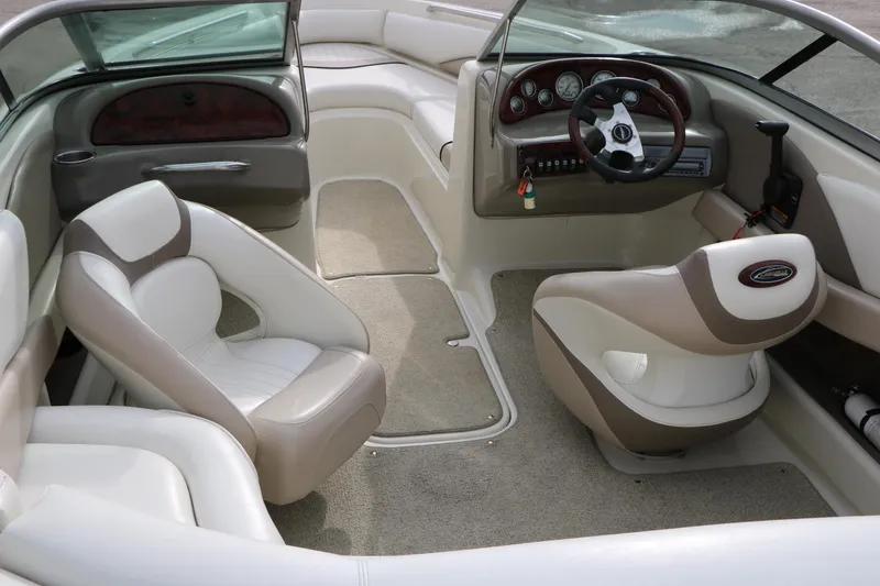 Slide: The Image of 2006 Caravelle 207 Bow Rider interior with beige seating and dashboard controls. - 13