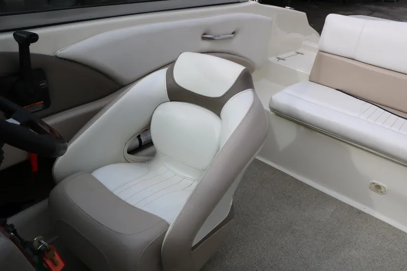 Slide: The Image of Interior of a 2006 Caravelle 207 Bow Rider boat, featuring beige and white seating. - 33