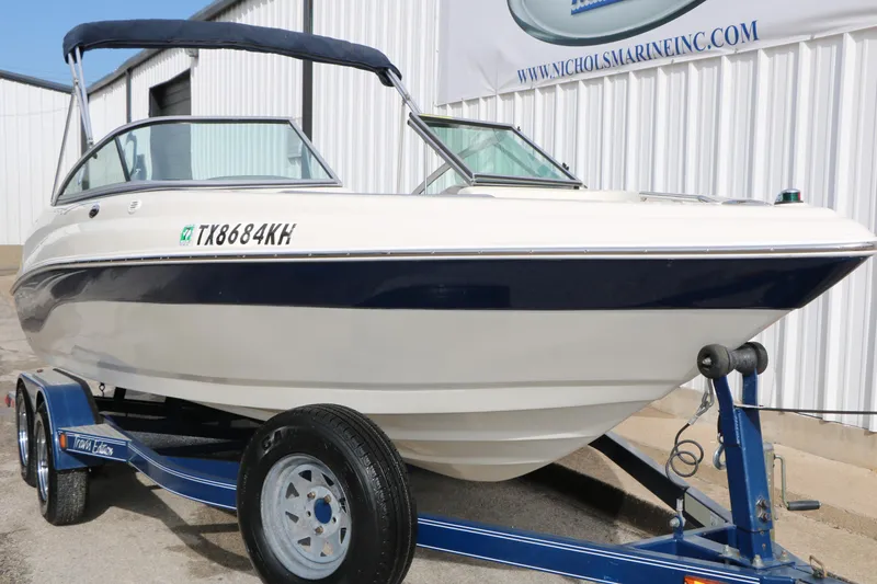 Slide: The Image of 2006 Caravelle 207 Bow Rider boat on trailer, parked outdoors. - 4