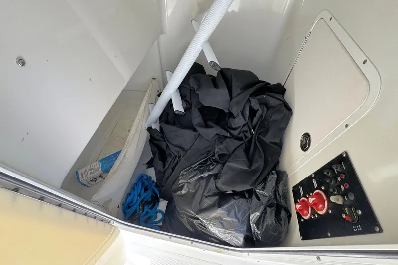 Slide: The Image of Storage compartment of 2011 Sea Hunt Gamefish 25 with ropes, tarp, and control panel. - 12