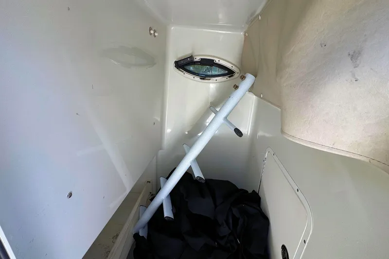 Slide: The Image of Interior cabin of a 2011 Sea Hunt Gamefish 25 boat, featuring storage and porthole. - 13