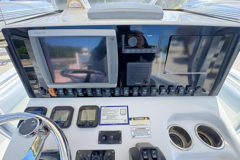 Slide: The Image of 2011 Sea Hunt Gamefish 25 dashboard with GPS, controls, and steering wheel. - 9