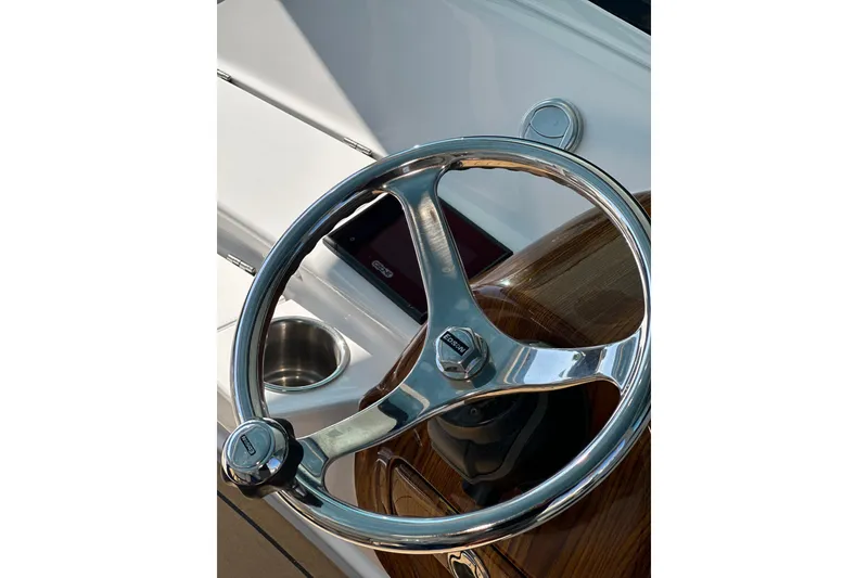 Slide: The Image of Steering wheel of 2021 HCB 65 Estrella boat, featuring sleek chrome design. - 11