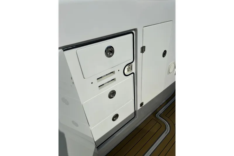 Slide: The Image of Storage compartments on a 2021 HCB 65 Estrella boat, featuring sleek design and secure locks. - 28