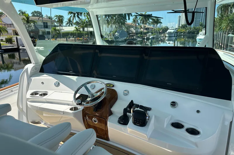 Slide: The Image of Helm of 2021 HCB 65 Estrella yacht with modern controls and scenic waterfront view. - 56