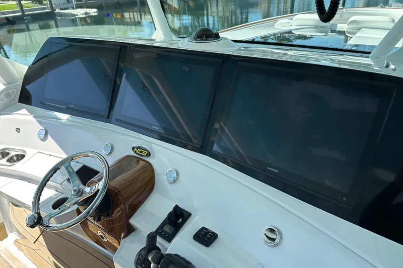 Slide: The Image of Helm of 2021 HCB 65 Estrella with triple Garmin displays and sleek steering wheel. - 69